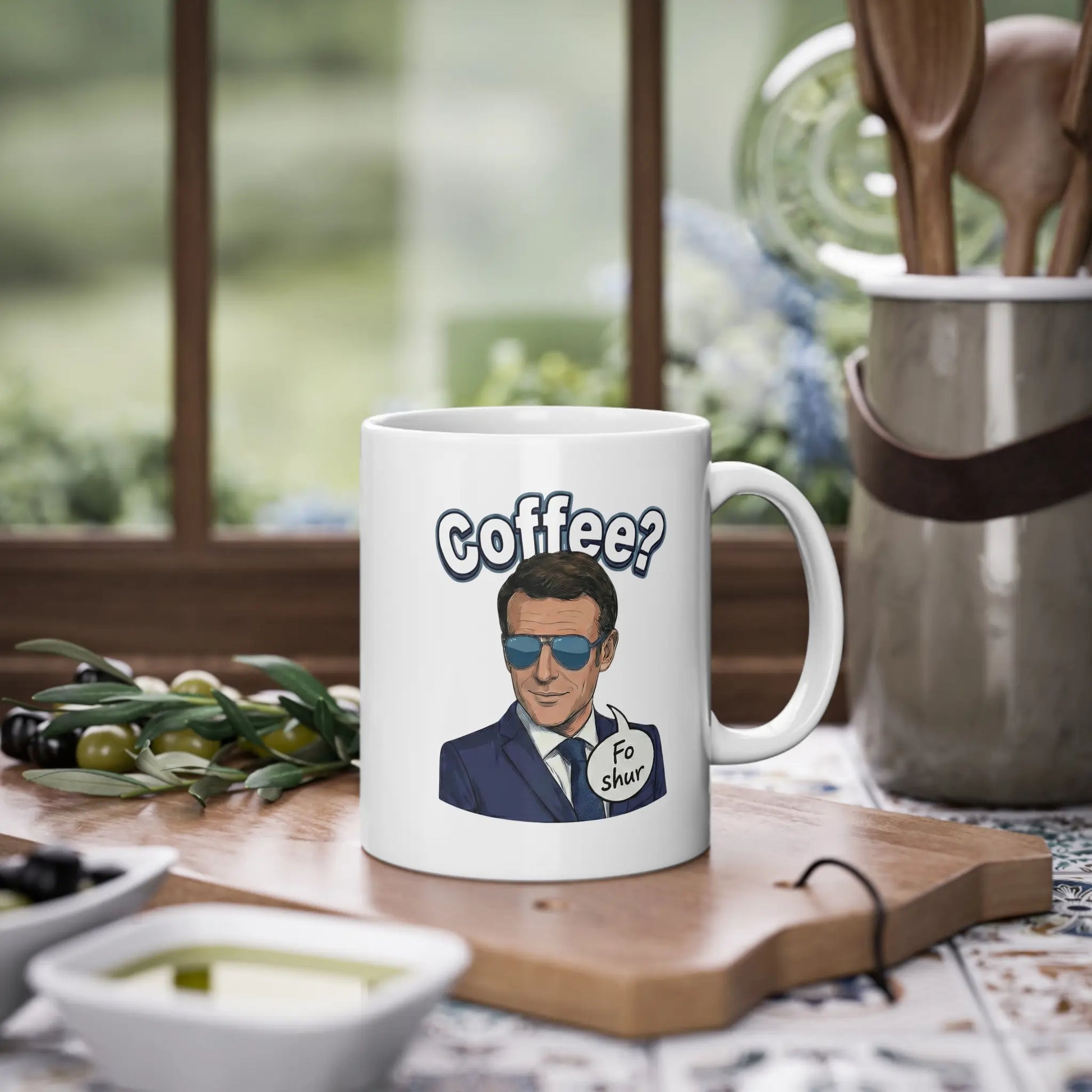 Emmanuelle Macron Tasse steht auf einem Schneidebrett. Das Design zeigt den Macron fo shur Spruch. Ideal als lustige Politik Tasse für das Büro. Zeigt Humor und Liebe zu EU Memes.